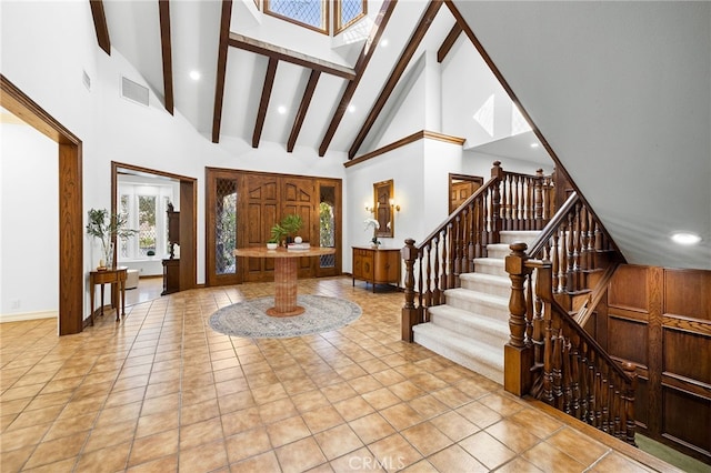 tiled entryway with high vaulted ceiling and beamed ceiling