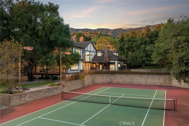 view of tennis court featuring a mountain view and basketball hoop