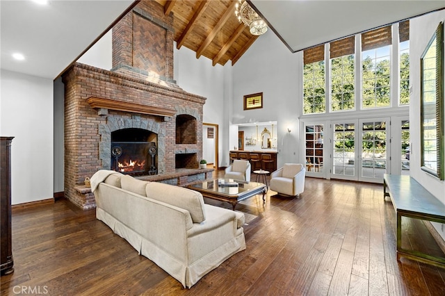 living room with beam ceiling, a fireplace, hardwood / wood-style floors, and high vaulted ceiling