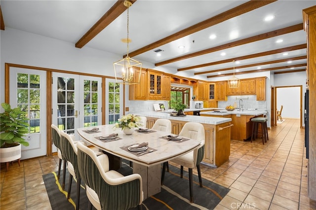 tiled dining space with beam ceiling, french doors, and a chandelier