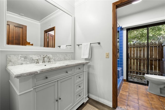 bathroom featuring toilet, ornamental molding, tile patterned flooring, and vanity