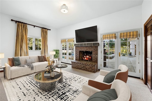 carpeted living room with a brick fireplace and french doors