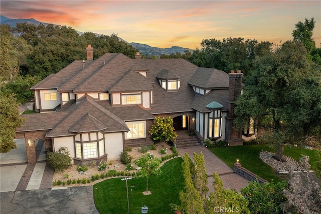 view of front of house with a mountain view and a yard