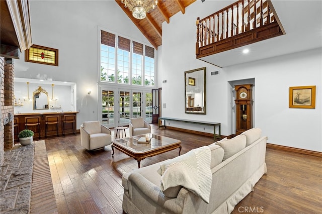 living room featuring dark hardwood / wood-style floors, beam ceiling, an inviting chandelier, wood ceiling, and high vaulted ceiling