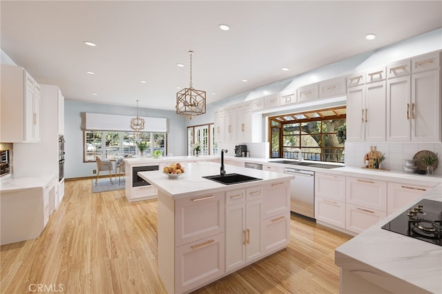 kitchen featuring tasteful backsplash, white cabinets, appliances with stainless steel finishes, and pendant lighting