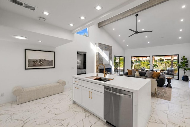 kitchen featuring sink, stainless steel dishwasher, beamed ceiling, a kitchen island with sink, and white cabinets