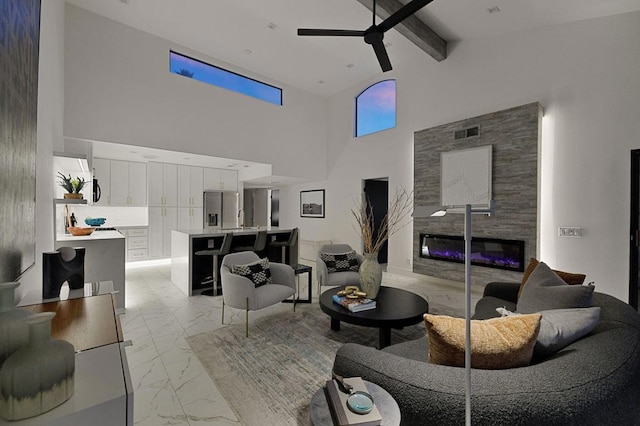 living room featuring ceiling fan, beam ceiling, sink, and a high ceiling