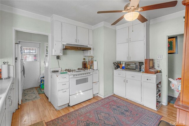 kitchen featuring custom exhaust hood, white stove, and white cabinetry