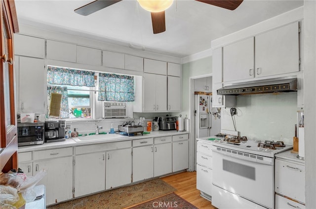 kitchen with light hardwood / wood-style floors, sink, white range, custom range hood, and white cabinets