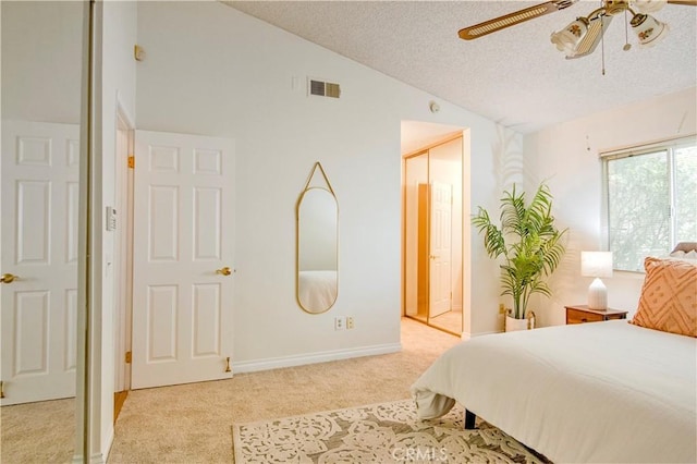 bedroom featuring a textured ceiling, ceiling fan, light colored carpet, and vaulted ceiling