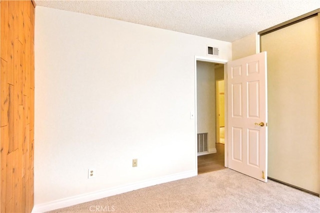 carpeted spare room with a textured ceiling