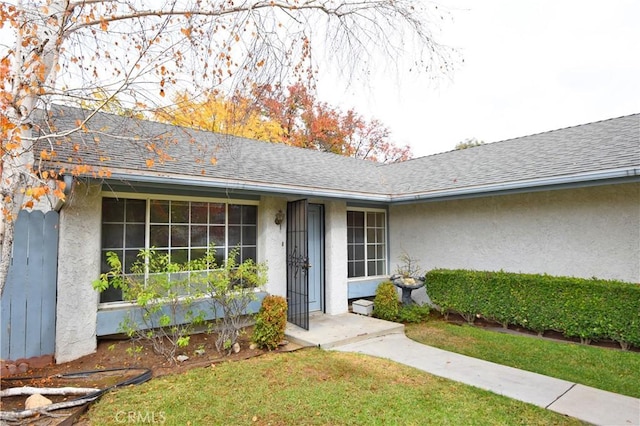 doorway to property with a lawn