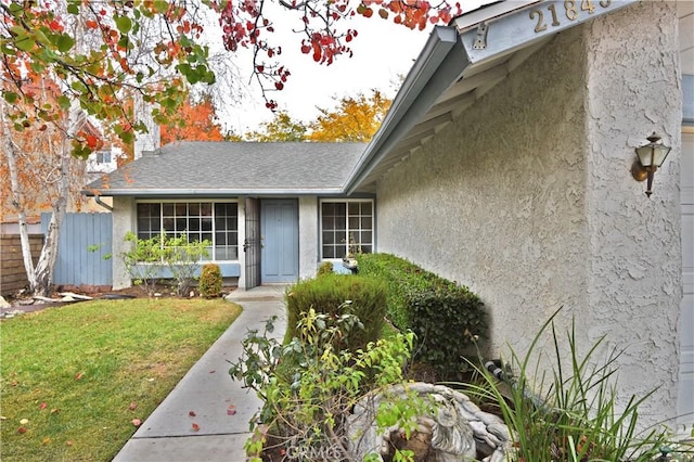 view of exterior entry featuring a lawn