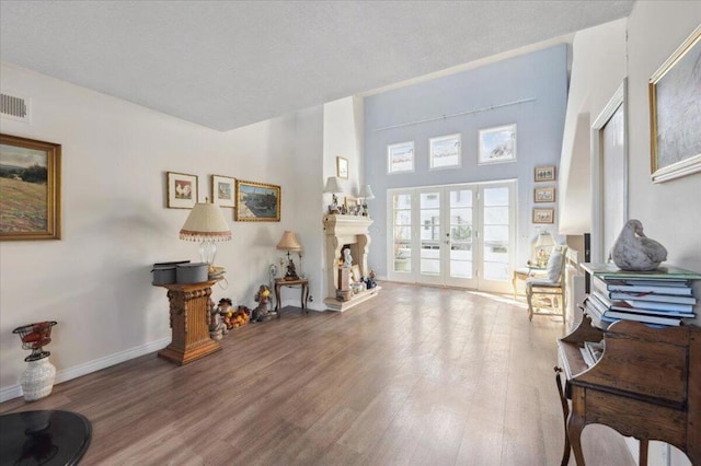 misc room with french doors, a high ceiling, and hardwood / wood-style floors