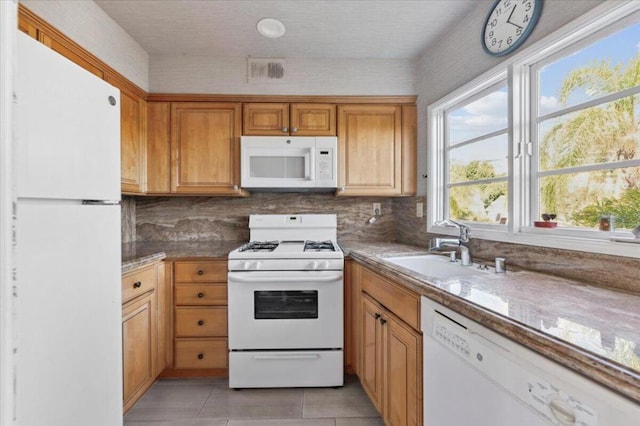 kitchen featuring backsplash, white appliances, sink, and light tile patterned floors