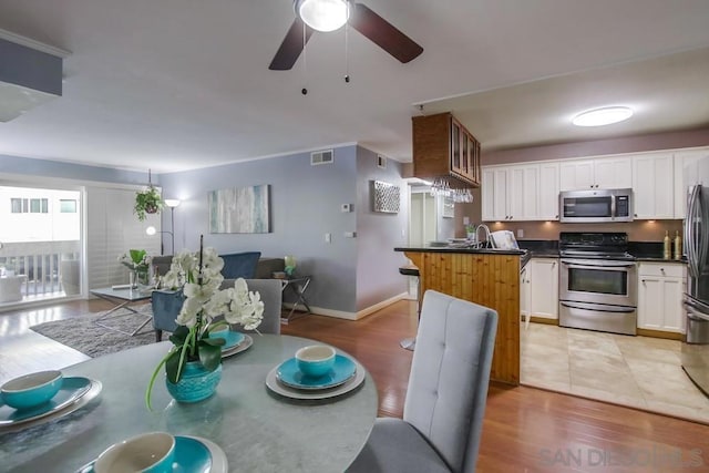 kitchen featuring light hardwood / wood-style floors, white cabinetry, and stainless steel appliances