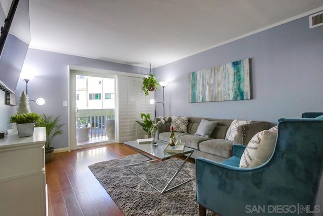 living room with wood-type flooring and crown molding