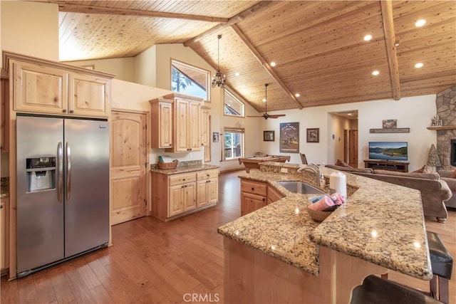 kitchen with stainless steel fridge, wooden ceiling, open floor plan, light brown cabinetry, and a sink