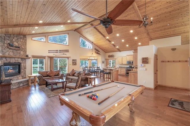 recreation room with wooden ceiling, light wood-style floors, beam ceiling, and a stone fireplace