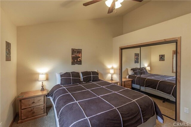 carpeted bedroom with ceiling fan, a closet, and vaulted ceiling