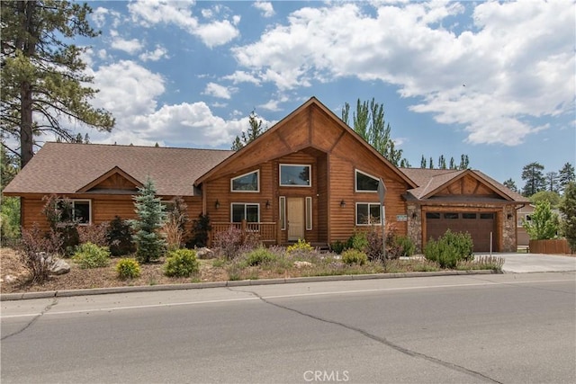 log home with driveway, roof with shingles, and an attached garage