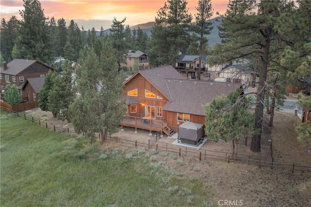 back house at dusk with a wooden deck