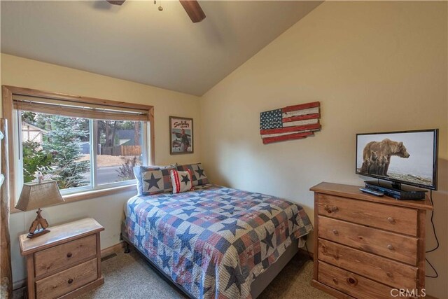 carpeted bedroom featuring visible vents, vaulted ceiling, and ceiling fan