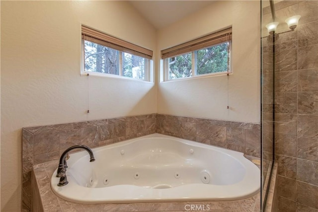 bathroom with a tub with jets and plenty of natural light