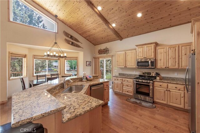 kitchen with high vaulted ceiling, wood-type flooring, a breakfast bar area, wood ceiling, and appliances with stainless steel finishes