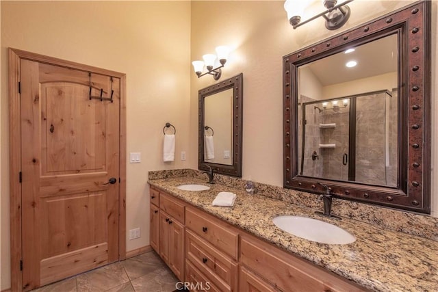 bathroom with double vanity, a shower stall, and a sink