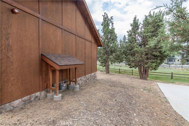 view of home's exterior featuring a barn, an outdoor structure, and fence