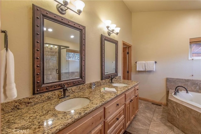 bathroom featuring vanity, a healthy amount of sunlight, and tiled tub