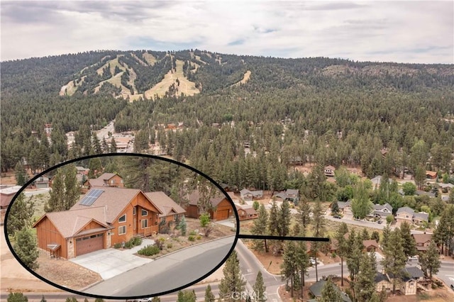 aerial view featuring a wooded view and a mountain view