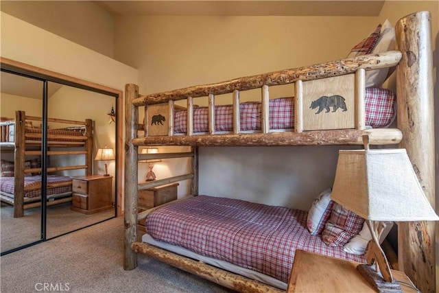 bedroom with a closet, carpet floors, and vaulted ceiling