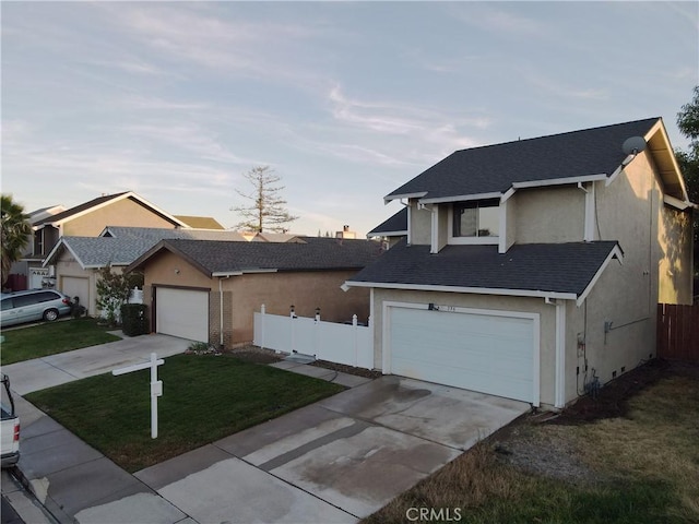 view of property featuring a garage and a lawn