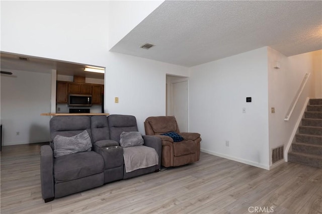 living room featuring a textured ceiling and light hardwood / wood-style flooring