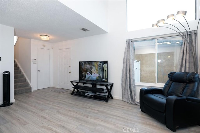 living area featuring light hardwood / wood-style flooring and a textured ceiling