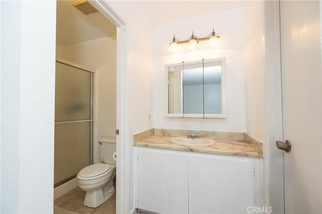 bathroom with tile patterned flooring, vanity, toilet, and a shower with shower door