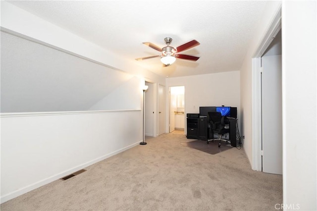 carpeted home office featuring ceiling fan