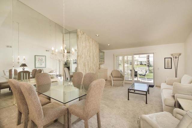 dining area featuring light colored carpet, high vaulted ceiling, and a chandelier