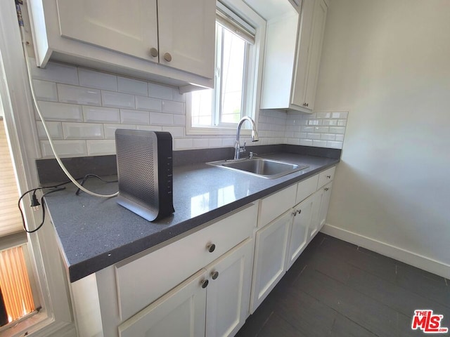 kitchen with white cabinets, tasteful backsplash, and sink