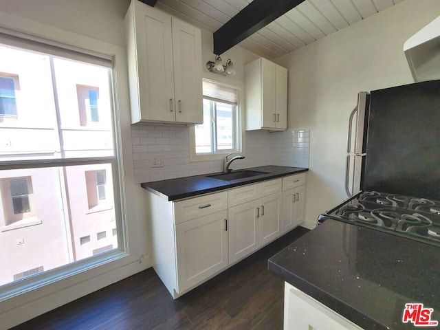 kitchen featuring dark wood-type flooring, sink, tasteful backsplash, white cabinetry, and stainless steel refrigerator