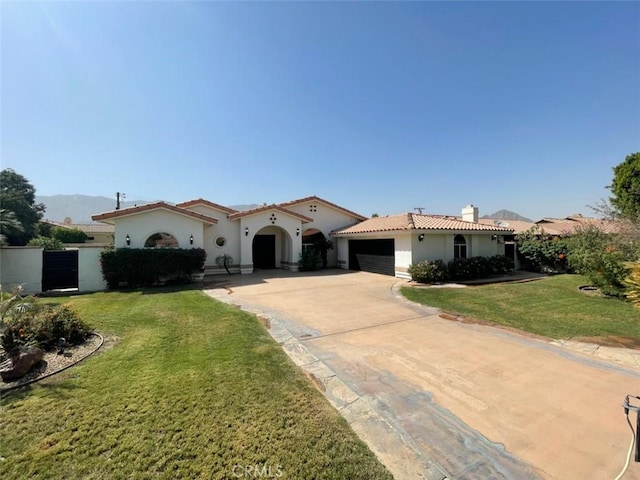 mediterranean / spanish house featuring a garage and a front lawn