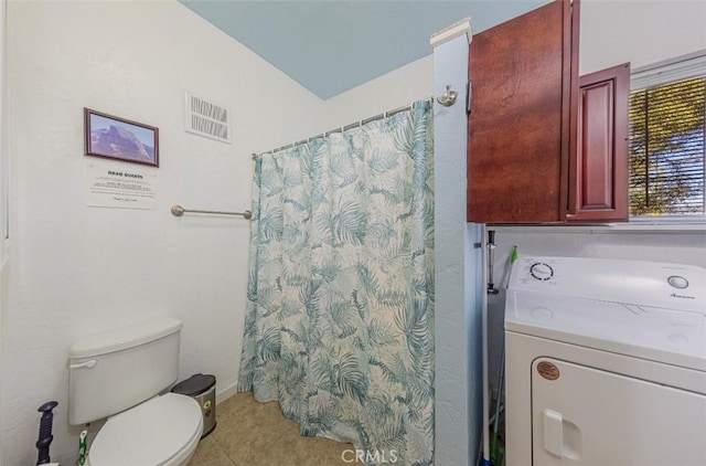 bathroom featuring washer / clothes dryer, curtained shower, tile patterned flooring, and toilet