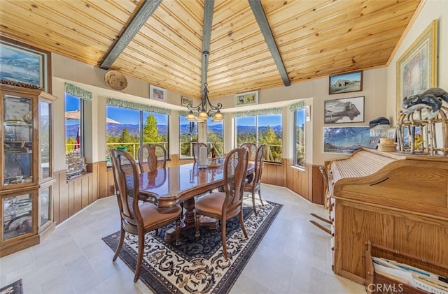 dining area with wood ceiling, an inviting chandelier, wood walls, beamed ceiling, and light tile patterned flooring