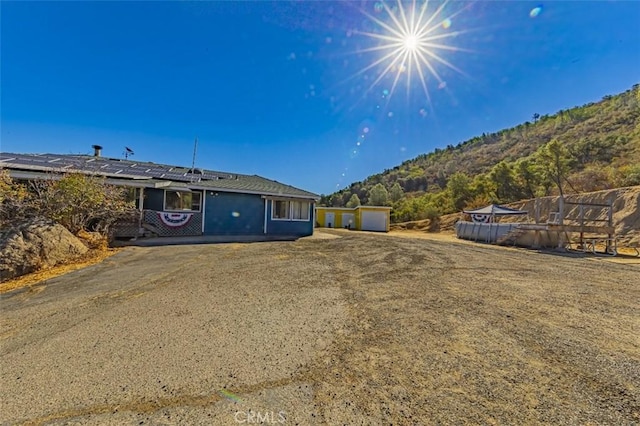 exterior space with a mountain view, a swimming pool, and an outdoor structure