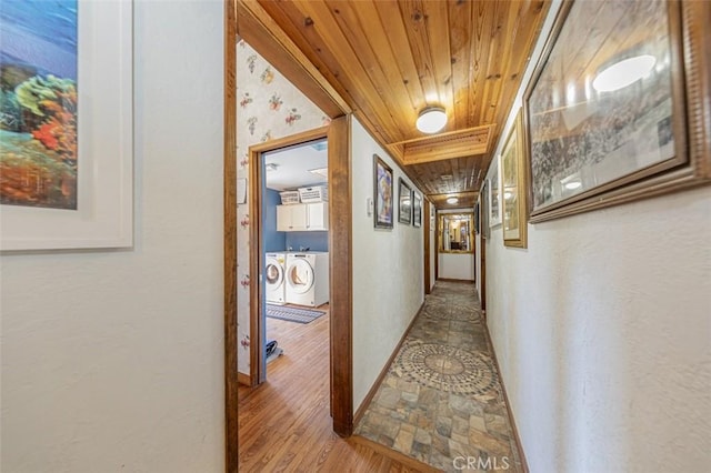 hallway featuring independent washer and dryer, wood-type flooring, and wood ceiling