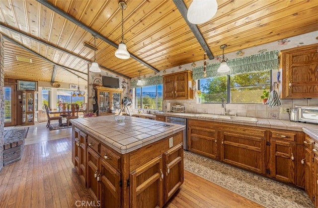 kitchen featuring tile countertops, a center island, light hardwood / wood-style floors, and hanging light fixtures