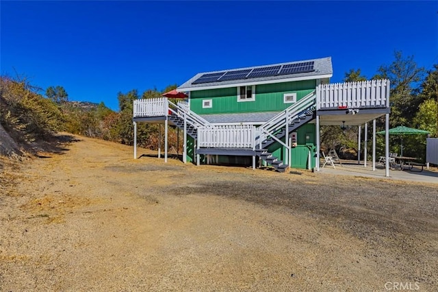 view of front of house with a wooden deck and solar panels