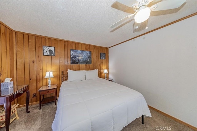 bedroom featuring carpet flooring, ceiling fan, wooden walls, and a textured ceiling